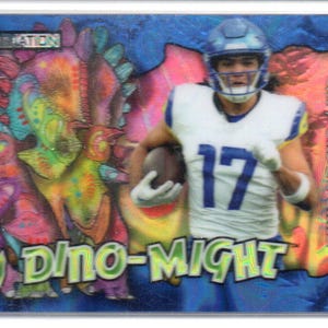 May include: A football trading card with a player in a blue and white uniform, number 17. The card has a colourful dinosaur graphic and the words "Dino-Might". The card is in a protective sleeve.