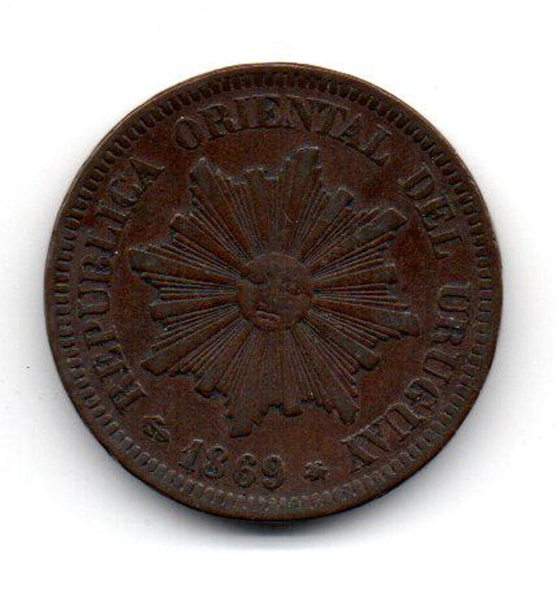 May include: A copper-colored coin with the text "REPUBLICA ORIENTAL DEL URUGUAY" and "$ 1869 $" around a stylized sunburst design.