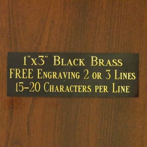 May include: A black brass plaque with gold lettering that reads "1"x3" BLACK BRASS FREE ENGRAVING 2 OR 3 LINES 15-20 CHARACTERS PER LINE".