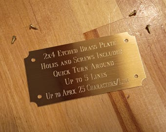May include: A rectangular brass plate with rounded corners and etched text. The text reads "2x4 ETCHED BRASS PLATE HOLES AND SCREWS INCLUDED QUICK TURN AROUND UP TO 5 LINES UP TO APRX. 25 CHARACTERS/LINE." Several screws are scattered around the plate.