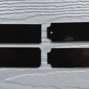 May include: Four black metal nameplates, two rectangular and two with scalloped edges. The nameplates are blank and ready for personalization.