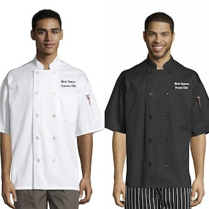 May include: Two chefs wearing white and black short-sleeved chef jackets with their names and titles embroidered on the left chest. The chef on the left is wearing a white jacket with the text "Mark Spencer Executive Chef" embroidered on it. The chef on the right is wearing a black jacket with the text "Mark Spencer Private Chef" embroidered on it.