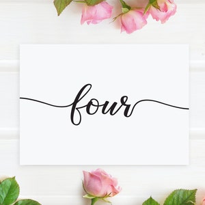 May include: White card with the word "four" written in black cursive script. The card is surrounded by pink roses.