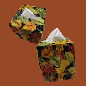 May include: A white ceramic mug with a black handle and the text "But First, Coffee" in a black, handwritten-style font. The mug is on a white surface.