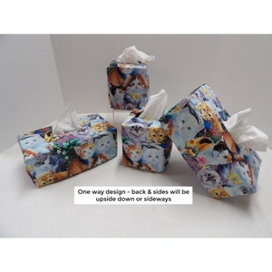 May include: Four tissue box covers with a colorful cat print. The covers are made of fabric and have a square shape. One way design - back & sides will be upside down or sideways.