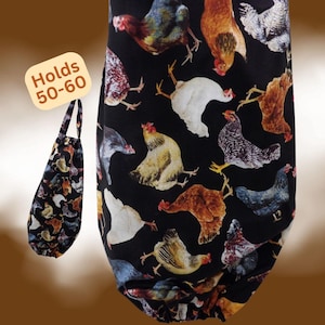 May include: A black fabric bag featuring a repeating pattern of various chicken breeds in shades of brown, white, gray, and black. The bag has a handle and an elasticized opening at the bottom. A label attached to the bag states: Holds 50-60.