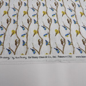 May include: White fabric with a repeating pattern of brown branches, yellow and blue birds. The text "Hydrangea Birdsong" and other details are printed along the bottom edge. Pattern #1761.