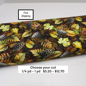 May include: Fabric with a brown background and a pattern of yellow, orange, and green leaves and pine cones. Choose your cut: 1/4 yard - 1 yard $3.20 - $12.70
