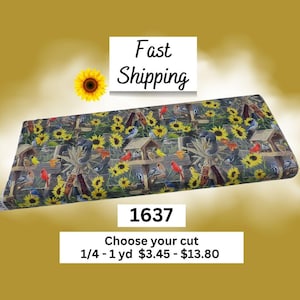 May include: A folded piece of fabric featuring a repeating pattern of sunflowers, wooden birdhouses, squirrels, and various birds including red cardinals and blue jays. The fabric has a dark background with yellow, red, and brown accents.