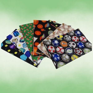 May include: A collection of fabric squares featuring sports-themed patterns. Designs include footballs, basketballs, baseballs, tennis rackets, and soccer balls. The fabrics are in various colors, including green, black, and white.