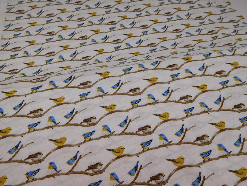 May include: White fabric with a repeating pattern of birds perched on brown branches. The birds are depicted in yellow, blue, and brown, creating a nature-inspired design. The branches are arranged in a diagonal pattern.