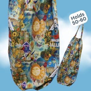 May include: A fabric bag with a hanging loop featuring a colorful print of yellow suns, blue birdhouses, red cardinals, sunflowers, and hot air balloons. A white label on the bag displays the text Holds 50-60, indicating its storage capacity.