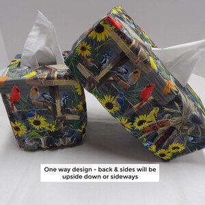 May include: Two fabric tissue box covers with a nature-themed pattern. The pattern features sunflowers, birds, and a wooden fence design. The text on the image reads: One way design - back & sides will be upside down or sideways.
