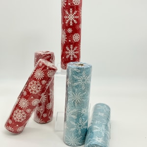 May include: Several rolls of decorative wrapping paper. The rolls are red and blue, with a repeating white snowflake pattern. The paper is wrapped in clear plastic, and is suitable for holiday or winter-themed gifts.