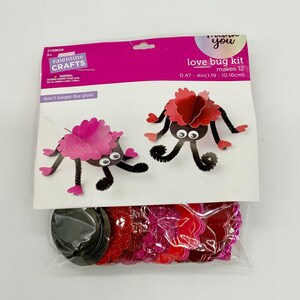 May include: A Valentine's Day craft kit to make 12 love bug decorations. The kit includes red and pink paper hearts, black pipe cleaners, googly eyes, and black circles. The package says "love bug kit makes 12 0.47 - 4in(1.19 - 10.16cm)" and "don't forget the glue!"