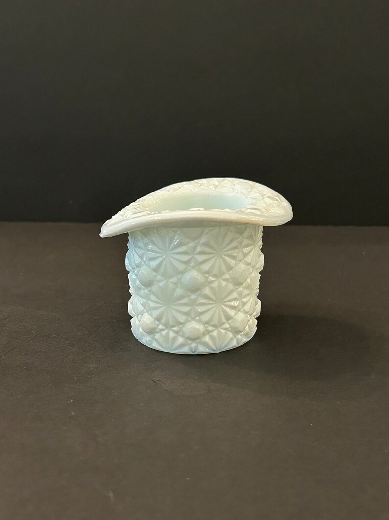 May include: A white milk glass hat shaped vase with a diamond pattern.