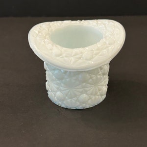 May include: A white milk glass hat shaped vase with a diamond pattern.