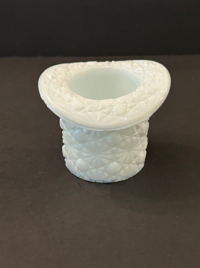 May include: A white milk glass hat shaped vase with a diamond pattern.