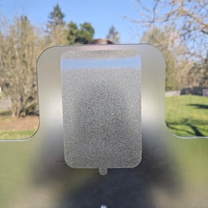 May include: A frosted glass panel with a textured, rectangular cutout in the center. The cutout is shaped like a popsicle.