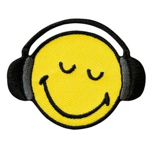 Könnte beinhalten: Ein gelbes Smiley-Gesicht mit geschlossenen Augen, das einen schwarzen Kopfhörer trägt. Das Smiley-Gesicht ist auf einem Stoff-Patch gestickt.