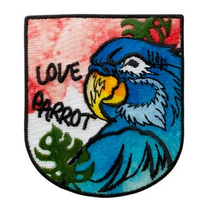 Può includere: Una toppa ricamata blu e gialla con un pappagallo e le parole "Love Parrot" su uno sfondo bianco con un motivo a macchie rosse e bianche.