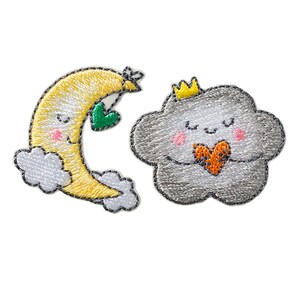 Puede incluir: Dos parches bordados para planchar, uno de una luna creciente amarilla con un corazón verde y el otro de una nube gris con una corona y un corazón naranja.