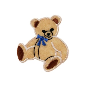 Puede incluir: Un oso de peluche marrón con una pajarita azul. El oso está sentado con las piernas cruzadas y los brazos extendidos. El oso está bordado con un diseño sencillo.