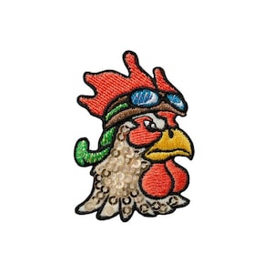 Könnte beinhalten: Gestickter Aufnäher eines Hahns mit Schutzbrille. Der Hahn ist rot, orange und gelb mit einem grün-weiß gemusterten Hals. Die Schutzbrille ist blau und weiß.