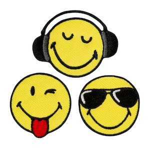 Peut inclure: Trois patchs brodés de visages jaunes souriants. Un visage souriant porte un casque, un autre porte des lunettes de soleil et un autre a la langue qui sort.