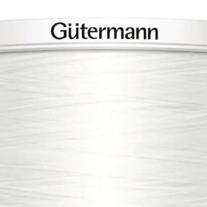 Könnte beinhalten: Eine weiße Spule Gütermann-Garn.