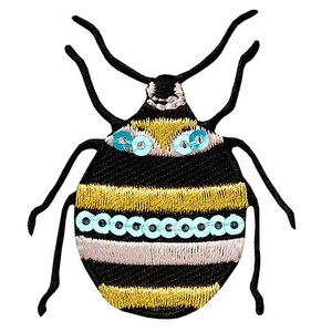 Stryklapp av en liten, knubbig skalbagge med paljetter, lappar, sybehör, sytillbehör