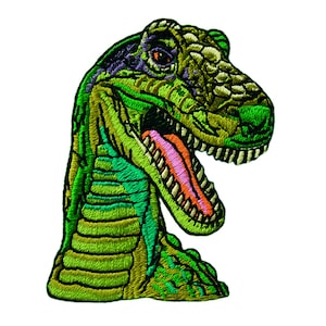 Pode incluir: Patch bordado de cabeça de dinossauro verde e amarelo com a língua rosa para fora. O dinossauro tem uma textura escamosa verde e amarela.
