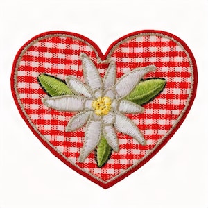 Op de afbeelding: Een hartvormige geborduurde patch met een rood-wit geblokte achtergrond. In het midden van het hart staat een gedetailleerde witte edelweissbloem met een geel hart en groene bladeren, omlijnd door een dikke rode geborduurde rand.