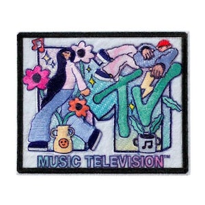 Può includere: Toppa ricamata con il logo MTV e un design colorato. Il design include illustrazioni di persone, fiori e note musicali. Le parole "MUSIC TELEVISION" sono stampate nella parte inferiore della toppa.