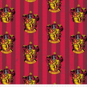 Könnte beinhalten: Roter und gelber Stoff mit einem sich wiederholenden Muster des Wappens des Gryffindor-Hauses aus der Harry-Potter-Reihe. Das Wappen zeigt einen Löwen, ein Schwert und die Worte "Gryffindor" auf einem Banner.