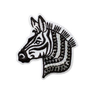 Könnte beinhalten: Schwarzer und weißer gestickter Zebra-Kopf-Patch mit schwarzen und weißen Perlendetails.