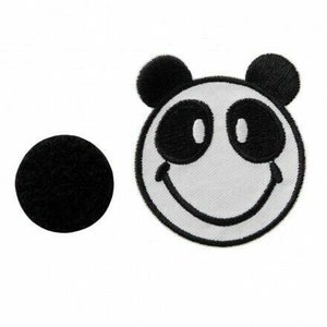 Könnte beinhalten: Schwarz-weiß gestickter Bügelaufkleber mit einem Panda mit einem Smiley-Gesicht. Der Panda hat schwarze Augen und eine schwarze Nase.