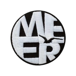 Op de afbeelding: Ronde, zwart geborduurde patch met het woord "MER" in wit. Een zwart vogelmotief is in het ontwerp verwerkt. Geschikt voor kleding of accessoires.
