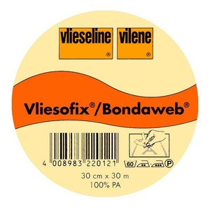 Könnte beinhalten: Eine Rolle Vliesofix/Bondaweb Bügelklebeband, ein weißer Stoff mit orangefarbenem Text und einem Barcode. Das Etikett lautet "Vliesofix/Bondaweb", "vlieseline", "vilene" und "30 cm x 30 m 100% PA".