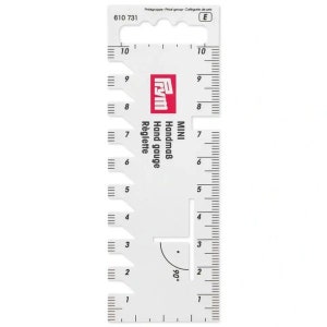 Puede incluir: Mini calibre de mano de plástico blanco con un logotipo Frym rojo y marcas para medir en pulgadas y centímetros. El calibre tiene un marcador de ángulo de 90 grados.