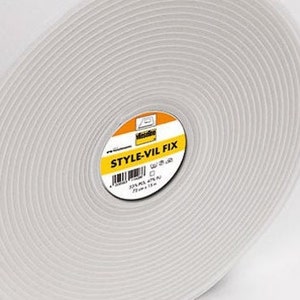 Könnte beinhalten: Eine Rolle weißes Klebeband mit einem gelben Etikett mit der Aufschrift "STYLE-VIL FIX".