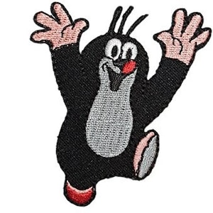 Op de afbeelding: Een zwarte en grijze cartoonmol met een rode neus en mond, die een zwart en grijs pak draagt, met beide armen in de lucht. De mol glimlacht en heeft een vrolijke uitdrukking.