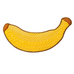 Pode incluir: Um remendo amarelo em forma de banana feito de lantejoulas. O remendo é contornado com fio marrom.