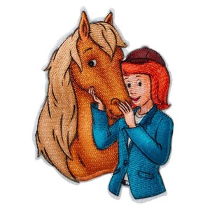 Op de afbeelding: Een geborduurde patch met een meisje met rood haar en een blauw jasje dat een bruin paard omhelst. Het paard heeft een blonde manen en staart.
