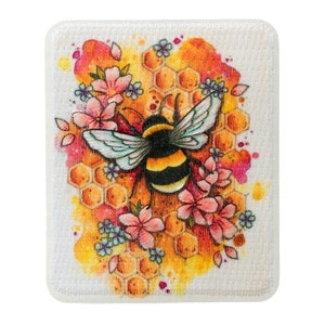 Può includere: Un'illustrazione ad acquerello di un bombo con strisce nere e gialle, circondato da fiori rosa e blu e un motivo a nido d'ape.