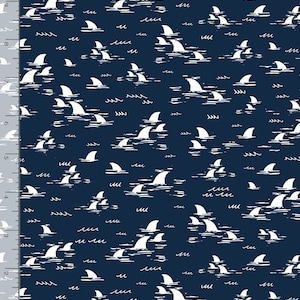 May include: A navy blue fabric with a white repeating pattern of shark fins and waves.