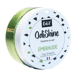 Könnte beinhalten: Ein Glas grüner Glitzergel namens "OdiShine" von Odif. Das Glas ist mit "Paillettes en gel" und "EMERAUDE" beschriftet. Das Etikett trägt außerdem die Aufschrift "Tissu et papier Lavable en machine".