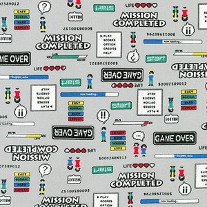 Könnte beinhalten: Ein grauer und weißer Stoff mit einem sich wiederholenden Muster aus pixelartigen Videospielgrafiken. Die Grafiken beinhalten die Wörter "Mission erfüllt", "Game Over", "Start", "Leben", "Einfach", "Normal", "Schwer", "Experte" und "Hallo".