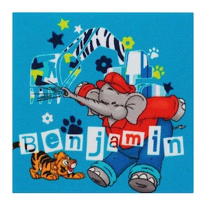 Op de afbeelding: Een blauwe achtergrond met een cartoon-olifant die een rood shirt en een blauwe broek draagt. De olifant houdt een waterslang vast en spuit water. Er is een tijger en de naam "Benjamin" in witte letters op de achtergrond.