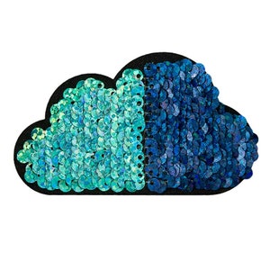 Könnte beinhalten: Ein blauer und türkisfarbener Pailletten-Patch in Wolkenform. Der Patch besteht aus Pailletten, die auf einen schwarzen Stoffgrund genäht sind.